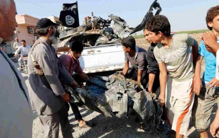 People carry a remnant of a war plane that crashed on the outskirts of Raqqa in northeast Syria September 16, 2014.