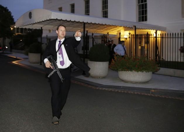 A U.S. Secret Service agent with an automatic rifle hurries people to evacuate the White House complex over a security alert moments after President Barack Obama and his family left for the presidential retreat, Camp David, in Maryland, September 19, 2014. A U.S. Secret Service agent with an automatic rifle hurries people to evacuate the White House complex over a security alert moments after President Barack Obama and his family left for the presidential retreat, Camp David, in Maryland, September 19, 2014