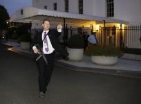 A U.S. Secret Service agent with an automatic rifle hurries people to evacuate the White House complex over a security alert moments after President Barack Obama and his family left for the presidential retreat, Camp David, in Maryland, September 19, 2014