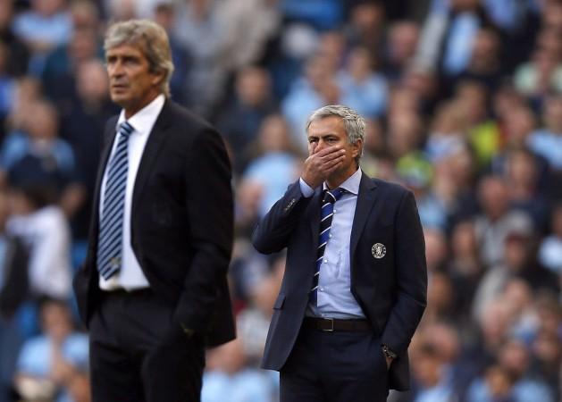 Chelsea manager Jose Mourinho (R) and Manchester City manager Manuel Pellegrini react during their English Premier League soccer match at the Etihad stadium in Manchester Maunel Pellegrini and Jose Mourinho