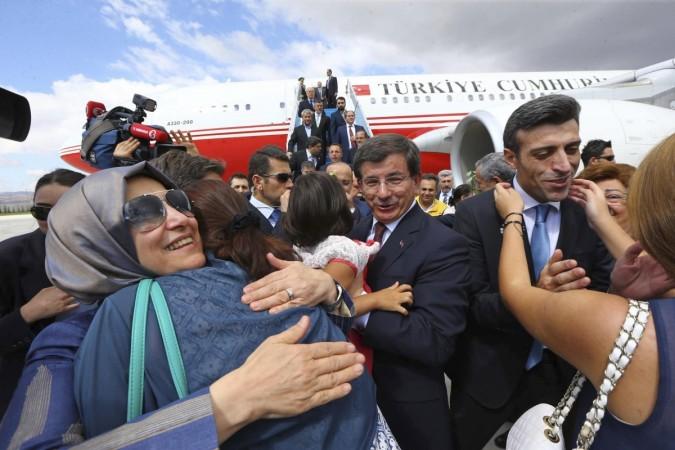 Turkish Consul General of Mosul Yilmaz is welcomed by his relatives as Turkish Prime Hakan Goktepe looks on.