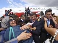 Turkish Consul General of Mosul Yilmaz is welcomed by his relatives as Turkish Prime Hakan Goktepe looks on.