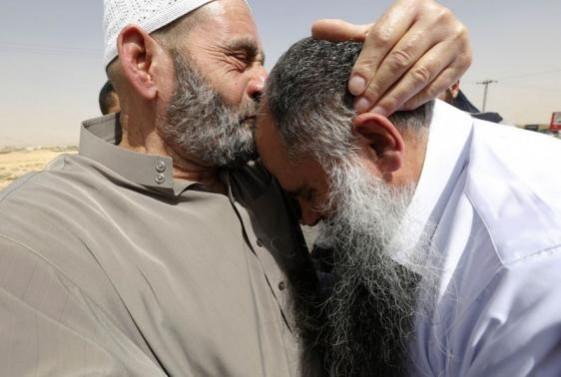 Abu Qatada (R) reacts as his father kisses his head after he was released from a prison Radical Muslim cleric Abu Qatada (R) reacts as his father kisses his head after he was released from a prison near Amman September 24, 2014.