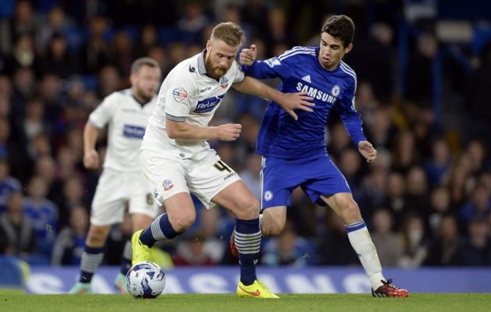 Bolton Wanderers' Matt Mills fights for the ball with Chelsea's Oscar (R) during the English League Cup soccer match at Stamford Bridge in London Chelsea