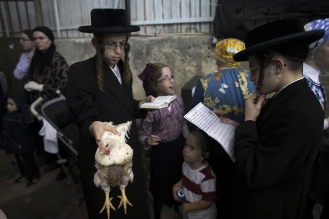 An ultra-Orthodox Jewish boy holds a chicken as he performs the Kaparot ritual in Jerusalem early morning on 2 October, ahead of Yom Kippur 2014, the Jewish Day of Atonement, which starts at sundown on Friday. Yom Kippur 2014 the Jewish Day of Atonement