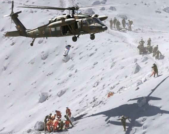 A hiker is lifted by a rescue helicopter of Japan Self-Defense Force (JSDF) during a rescue operation at Mt. Ontake, Japan's Ontake volcano eruption