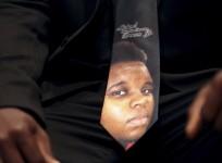 An unidentified man wears a tie decorated with a picture of Michael Brown, during funeral service at Friendly Temple Missionary Baptist Church in St. Louis, Missouri, August 25, 2014.