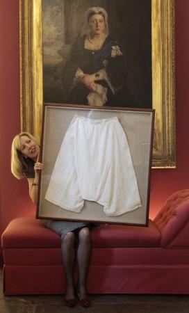 Kate Bain from Lyon and Turnbull auctioneers poses for photographers with a framed pair of silk bloomers undergarments that once belonged to Queen Victoria, during a photocall for the auction of the Forbes Collection in Edinburgh, Scotland October 27, 2011. Queen Victoria's silk bloomers sold at auction for £6,200.