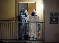 Workers in hazardous material suits step out of an apartment unit where a man diagnosed with the Ebola virus was staying in Dallas, Texas, October 5, 2014.