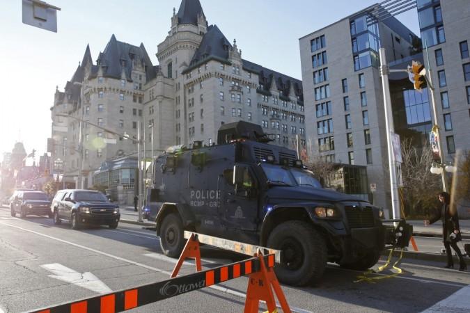A Royal Canadian Mounted Police vehicle passes the Fairmont Chateau Laurier as it leaves a secure area downtown following shootings in Ottawa on 22 October 2014. canada police