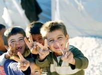 Kurdish refugee children from the Syrian town of Kobane flash victory signs in a camp in Suruc, Sanliurfa province.