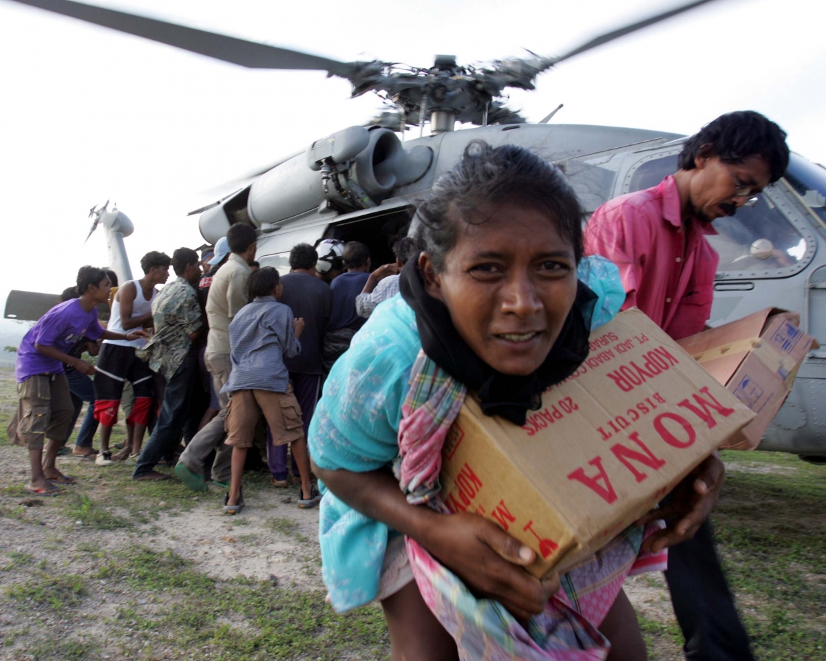 Tsunami refugees receive supplies distributed by USS Abraham Lincoln carrier strike group in Krueng Raya, northeast of Banda Aceh, Indonesia. Waves of Tsunami 2004 destroyed countries and killed many people