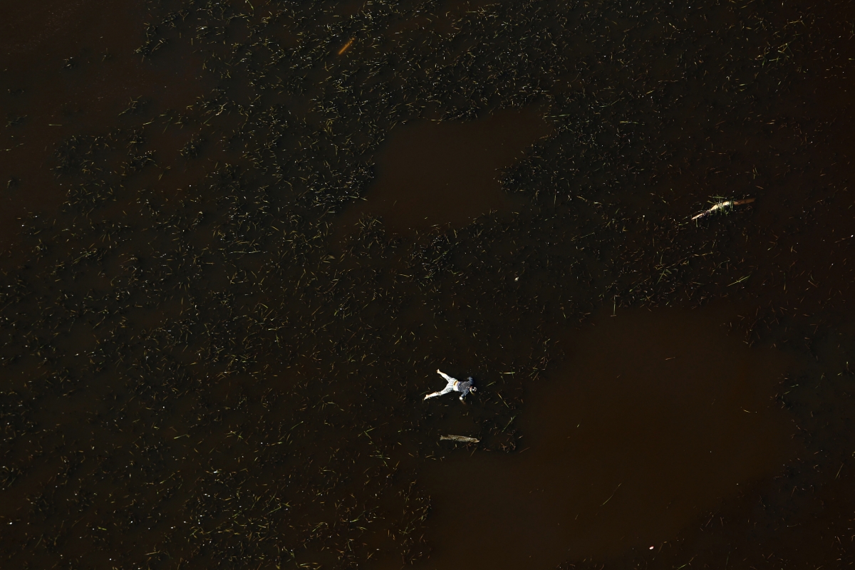 aerial view of a bloated body floating among debris in the sea as aftermath of Super Typhoon Haiyan