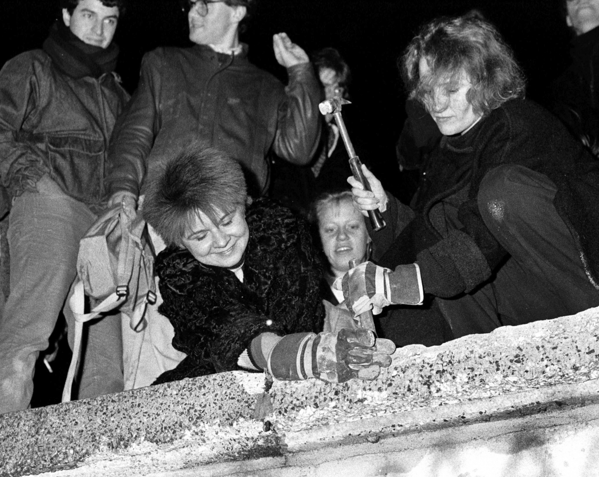 'Berlin Wall Fall' Silver Jubilee. (Photo: Berliners take a hammer and chisel to a section of the Berlin Wall in front of the Brandenburg Gate after the opening of the East German border was announced, November 9, 1989.) 'Berlin Wall Fall' Silver Jubilee