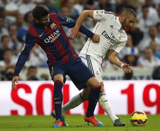 Barcelona defender Gerard Pique tussles for the ball with Real Madrid forward Karim Benzema in the El Clasico Gerard Pique Barcelona Karim Benzema Real Madrid
