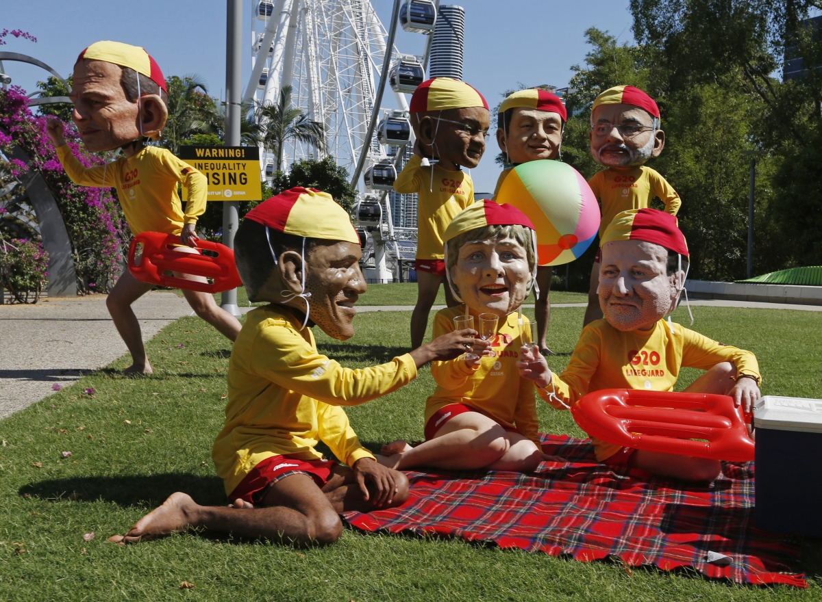 Protesters wearing masks depicting G20 leaders and dressed as Australian surf lifesavers call for global equality among nations outside the venue site of the annual G20 leaders summit in Brisbane, G20 Summit 2014
