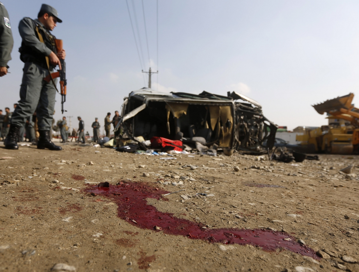 An Afghan policeman inspects the site of a suicide attack on a British embassy vehicle in Kabul, November 27, 2014. Kabul Suicide Attack