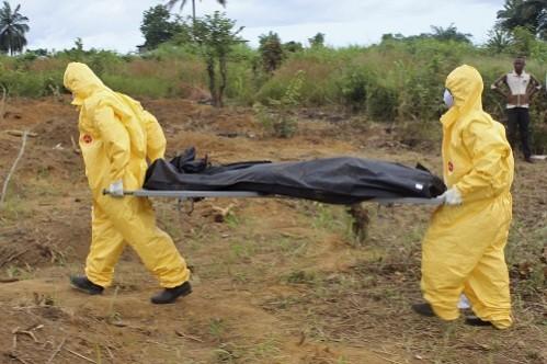 Health workers carry the body of an Ebola virus victim in the Waterloo district of Freetown. Ebola burial