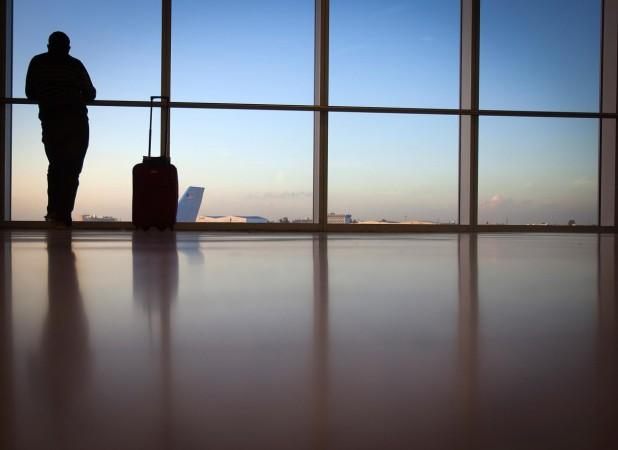 A passenger looks out the window at Miami International Airport in Miami