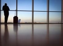 A passenger looks out the window at Miami International Airport in Miami