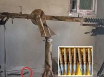 An ISIS fighter aims the giant 10 foot long sniper gun out of a window in Kobane. (inset): An image of the 23 mm bullet that is fired from the ISIS gun show in the pic.