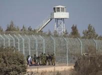 Israeli soldiers stand near the border with Syria in the occupied Golan Heights as they prepare to evacuate a wounded Syrian
