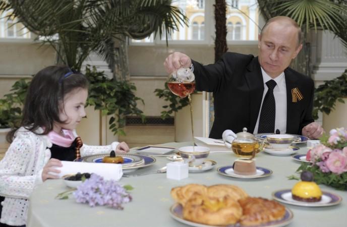 President Putin serving a cup of tea to a young girl