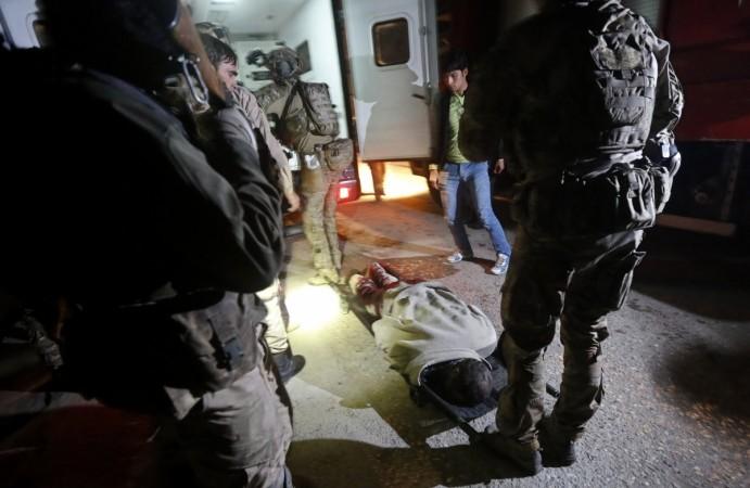 The dead body of a foreigner lies on the ground after a Taliban attack on a foreign aid workers' guest house in the Afghan capital of Kabul November 29, 2014. Taliban attack guest house