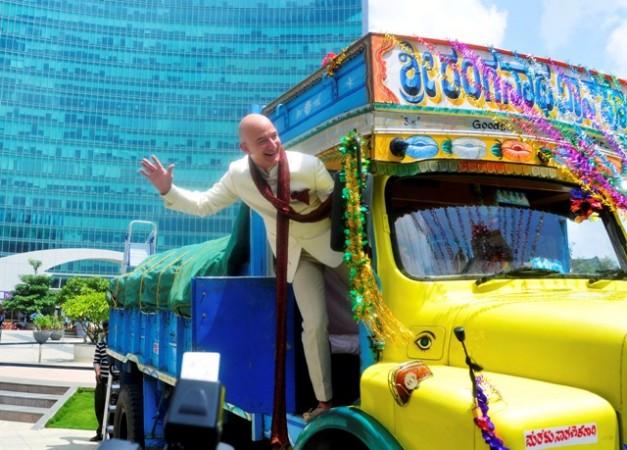 Jeff Bezos, founder and CEO of Amazon, stands on a supply truck during a photo opportunity at the premises of a shopping mall in Bangalore. Jeff Bezos