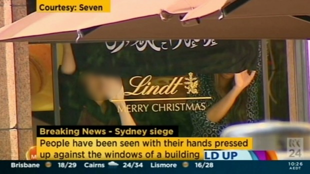 Hostages at the Lindt Cafe hold the Black flag. Hostages at the Lindt Cafe hold the Black flag.