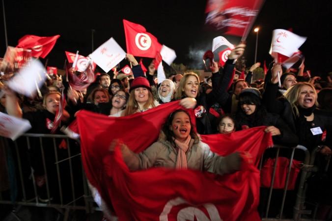 Supporters of the Nidaa Tounes (Call for Tunisia) secular party movement wave national flags flags and shout slogans in Tunis on 21 December 2014. Nidaa Tounes (Call for Tunisia) supporters wave flags and shout slogans