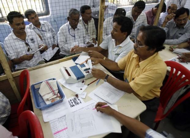 Election officials count votes from an Electronic Voting Machine (EVM) inside a ballot counting centre. elections