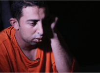 Muath al-Kasaesbeh is shown wearing an orange jumpsuit.