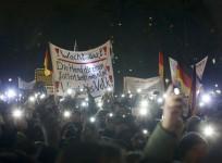 Participants use lights on their portable phones as they take part in a demonstration called by anti-immigration group PEGIDA, a German abbreviation for