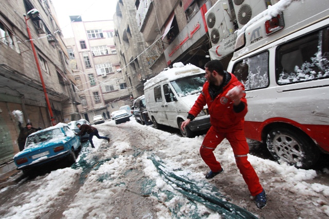 Civilians and members of the Syrian Arab Red Crescent play with snow in the Duma neighbourhood of Damascus. Syria Snow