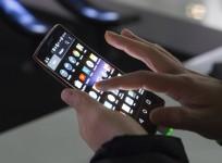 An attendee tries out a LG G Flex 2 curved smartphone during the 2015 International Consumer Electronics Show (CES) in Las Vegas, Nevada