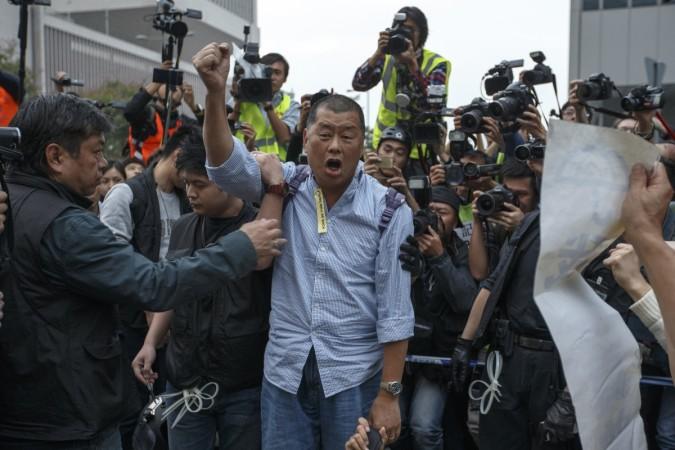 Media tycoon Jimmy Lai shouts slogan before he is taken away by police officer at an area previously blocked by pro-democracy supporters, outside the government headquarters in Hong Kong, December 11, 2014. Jimmy Lai Hong KOng