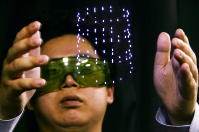 Tatsumi Kimura, researcher at Japan's National Institute of Advanced Industrial Science and Technology (AIST), shows laser plasma technology making a flashpoint in the air. The AIST succeeded in the experimental fabrication of the device displaying Japan's AIST
