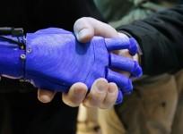 A man shakes hands with a robotic prosthetic hand in the Intel booth at the International Consumer Electronics show