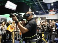 A man wearing an Oculus VR headset demonstrates a first person shooter game in a Virtuix Omni virtual reality system at the International Consumer Electronics show