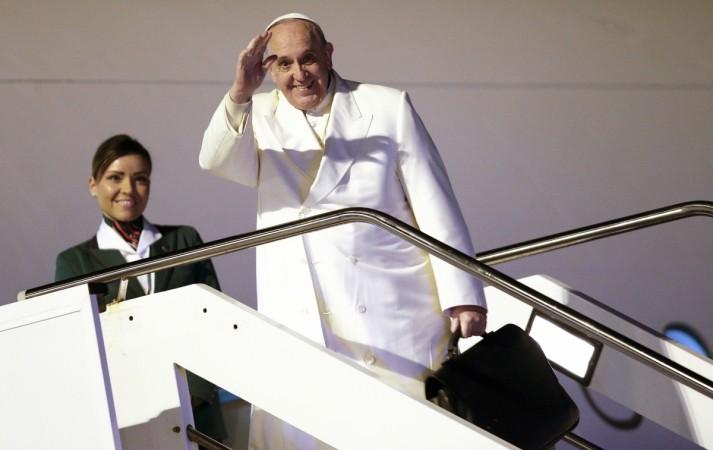 Pope Francis waves as he boards a plane for his trip to Sri Lanka and the Philippines at Fiumicino airport in Rome January 12, 2015. Pope Francis boards plane to Sri Lanka