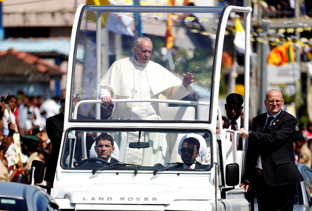 Pope Francis waves at devotees who gather on the road to see him after he arrived at the Colombo airport. Pope Francis in Sri Lanka