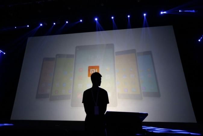 A security guard stands in front of a screen showing Xiaomi mobile phones A security guard stands in front of a screen showing Xiaomi mobile phones