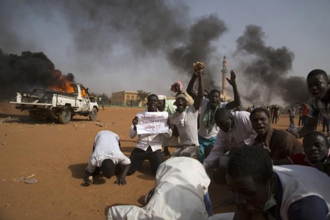 A man (2nd L) holds a sign reading Charlie Hebdo riots in Niger