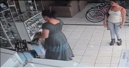 CCTV captured the footage of a woman walking out of a store with plasma tv up her dress woman walks out with plasma tv up her dress