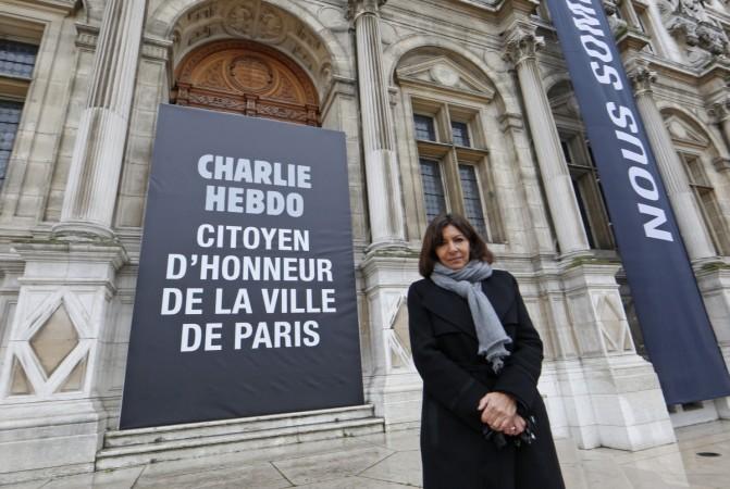 Paris Mayor Anne Hidalgo poses near a banner which reads Paris Mayor Anne Hidalgo