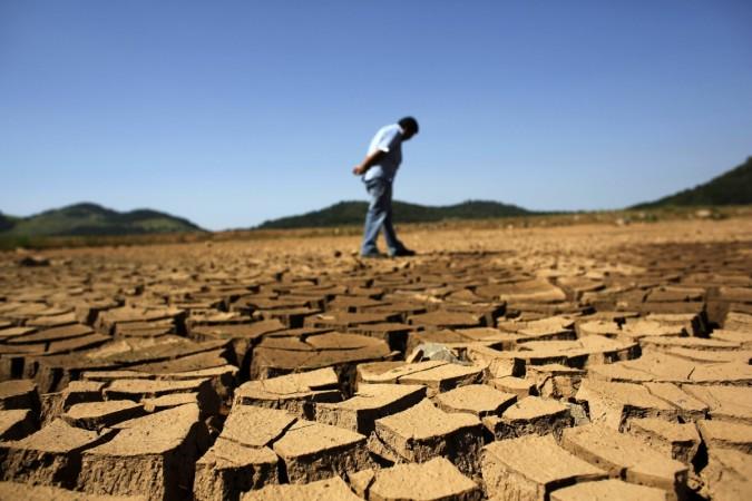 A worker from the Sao Paulo state company that provides water and sewage services to residential, commercial and industrial areas looks at the cracked ground of near Jaguary dam in Braganca Paulista, 100 km from Sao Paulo, in this file photo taken January