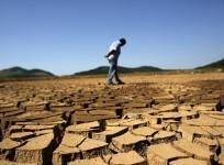 A worker from the Sao Paulo state company that provides water and sewage services to residential, commercial and industrial areas looks at the cracked ground of near Jaguary dam in Braganca Paulista, 100 km from Sao Paulo, in this file photo taken January