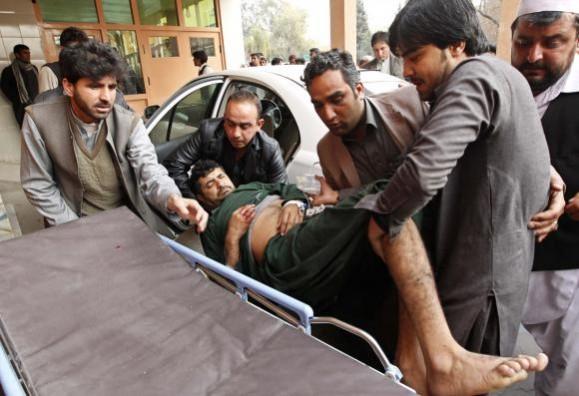 Afghan men carry a wounded man at a hospital in Jalalabad, after a suicide attack which targeted funeral prayers in Laghman province. Suicide bomb attack in Afghnistan