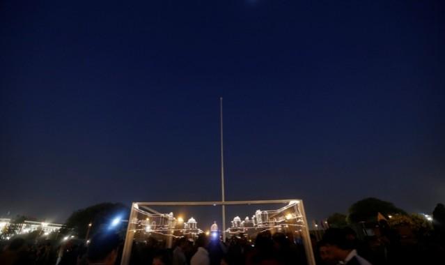 The illuminated Indian Defence Ministry (R), Presidential Palace (C) and Home Ministry are reflected in a bullet-proof screen during the Beating Retreat Ceremony